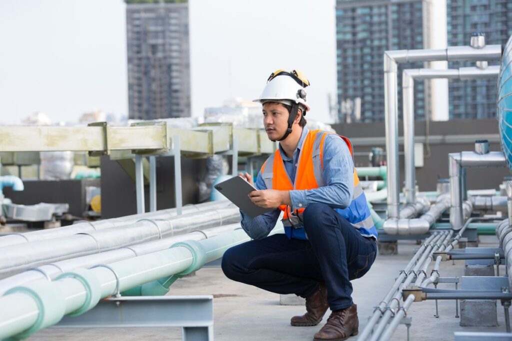 Un ingénieur en train d'examiner un chantier sur le toit d'un bâtiment